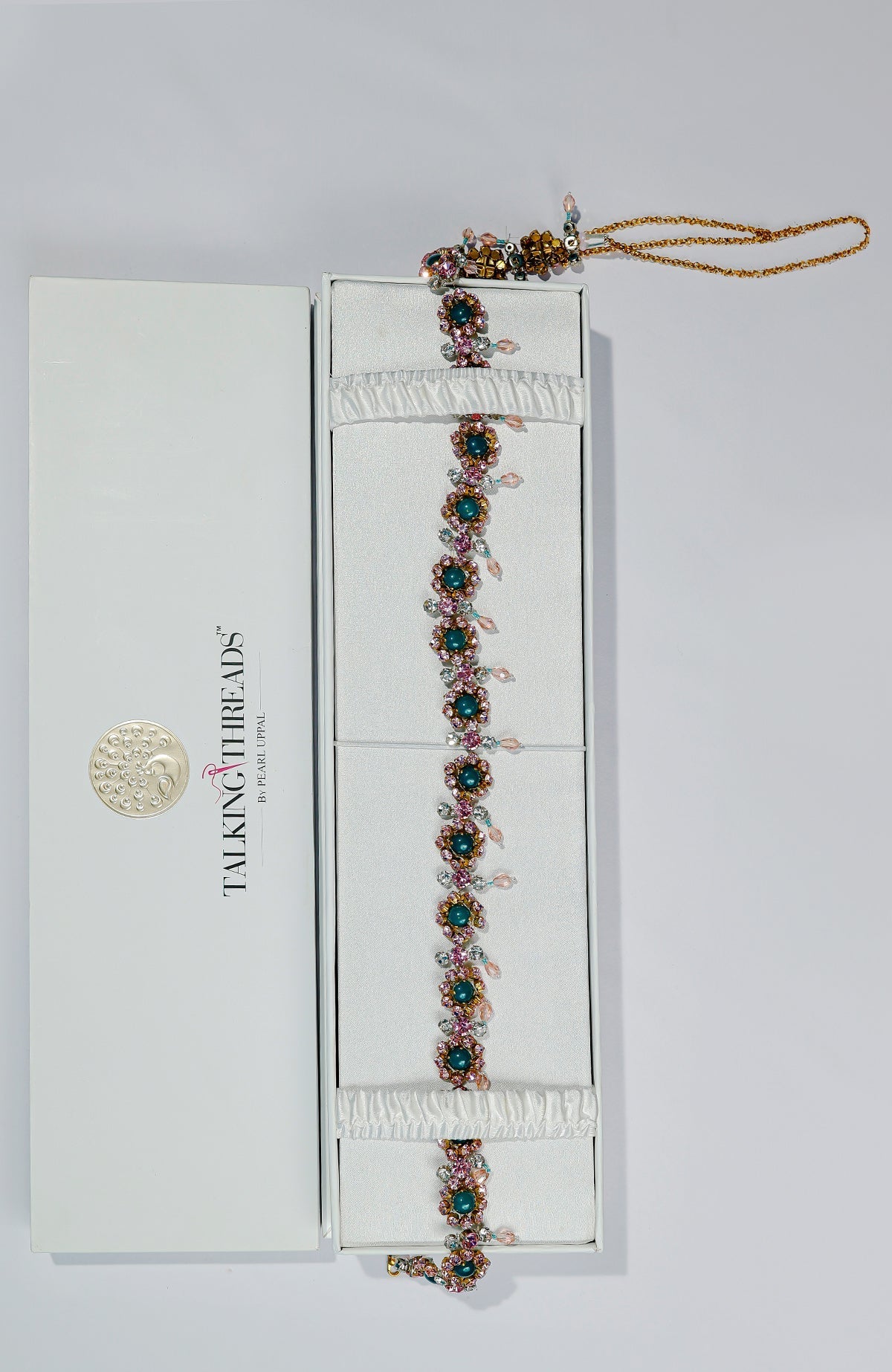 Pink belt adorned with green and pink crystals and golden dangling stones.