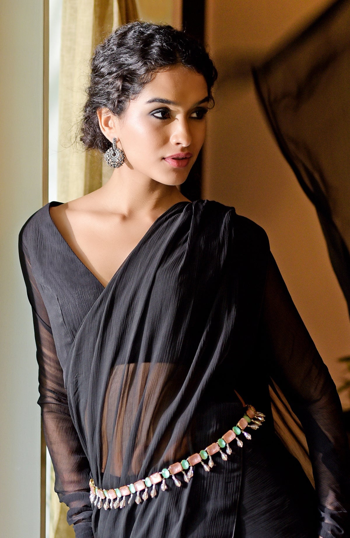 Black chiffon saree with a pink and green jeweled crystal belt.
