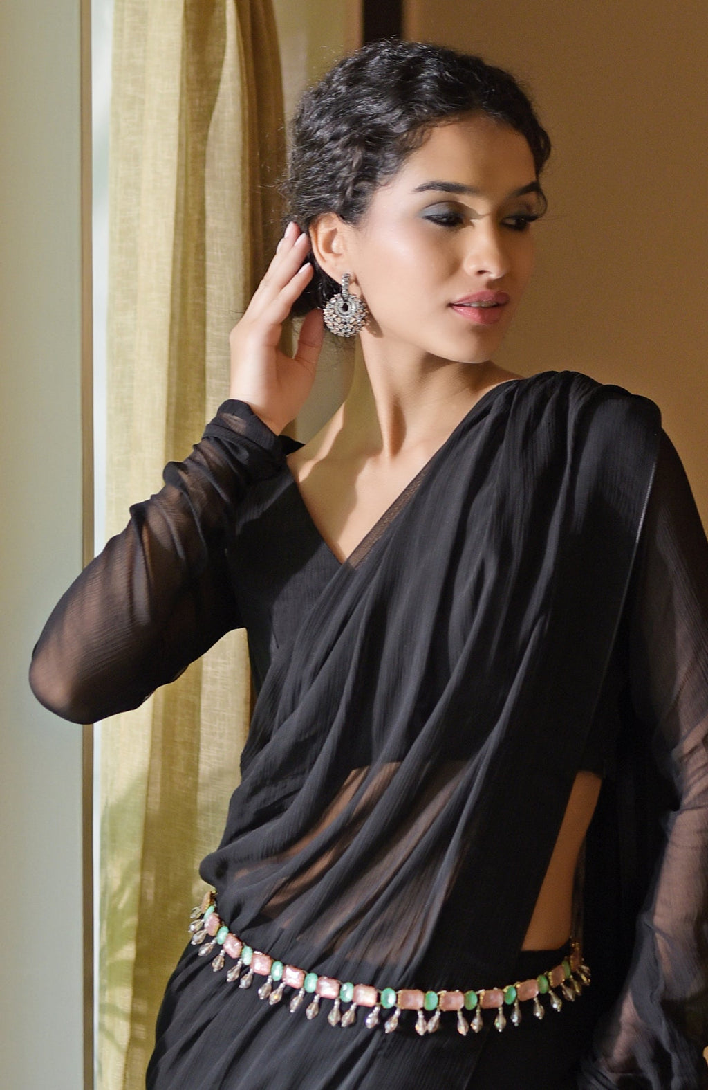 Black chiffon saree with a pink and green jeweled crystal belt.