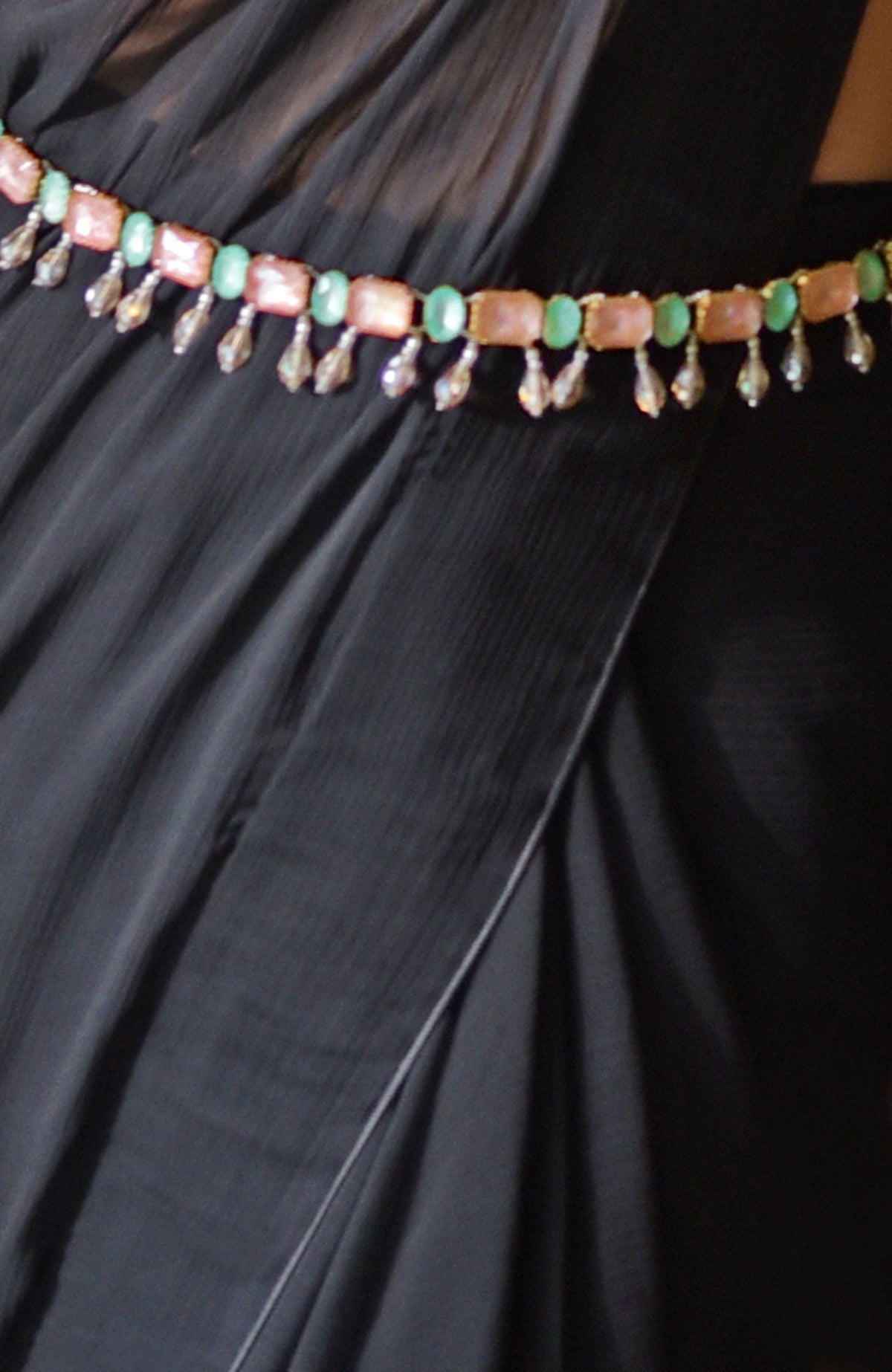 Black chiffon saree with a pink and green jeweled crystal belt.