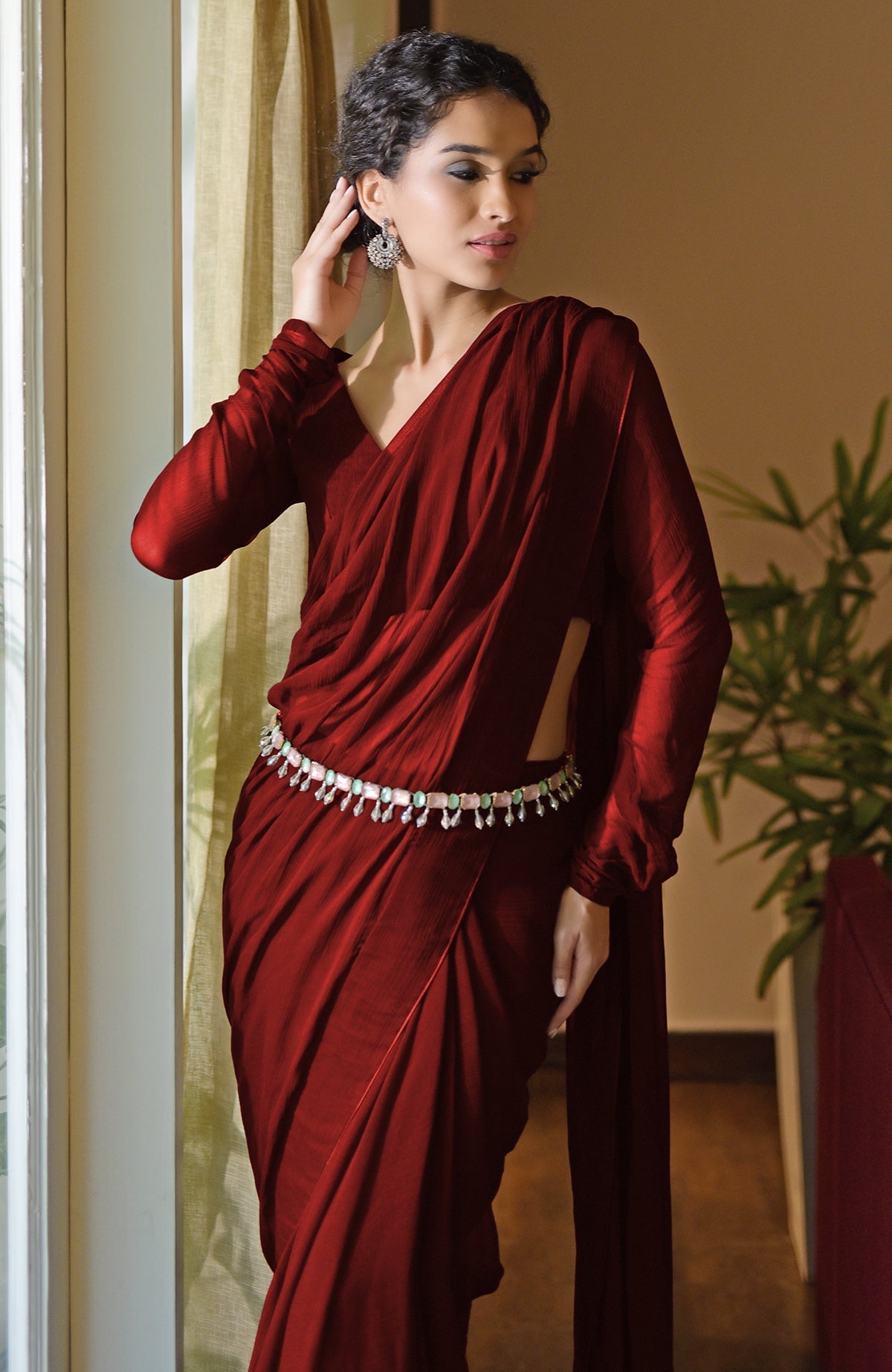 Classic blood red chiffon saree with pre-stitched design and matching blouse with sheer long sleeves.