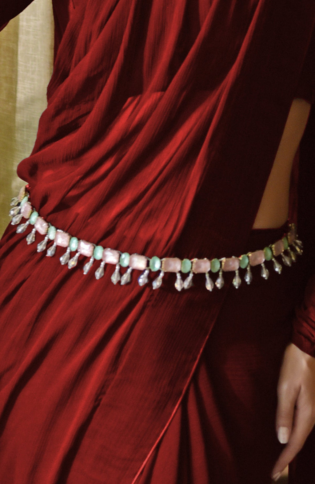Classic blood red chiffon saree with pre-stitched pleats and matching blouse with sheer long sleeves.