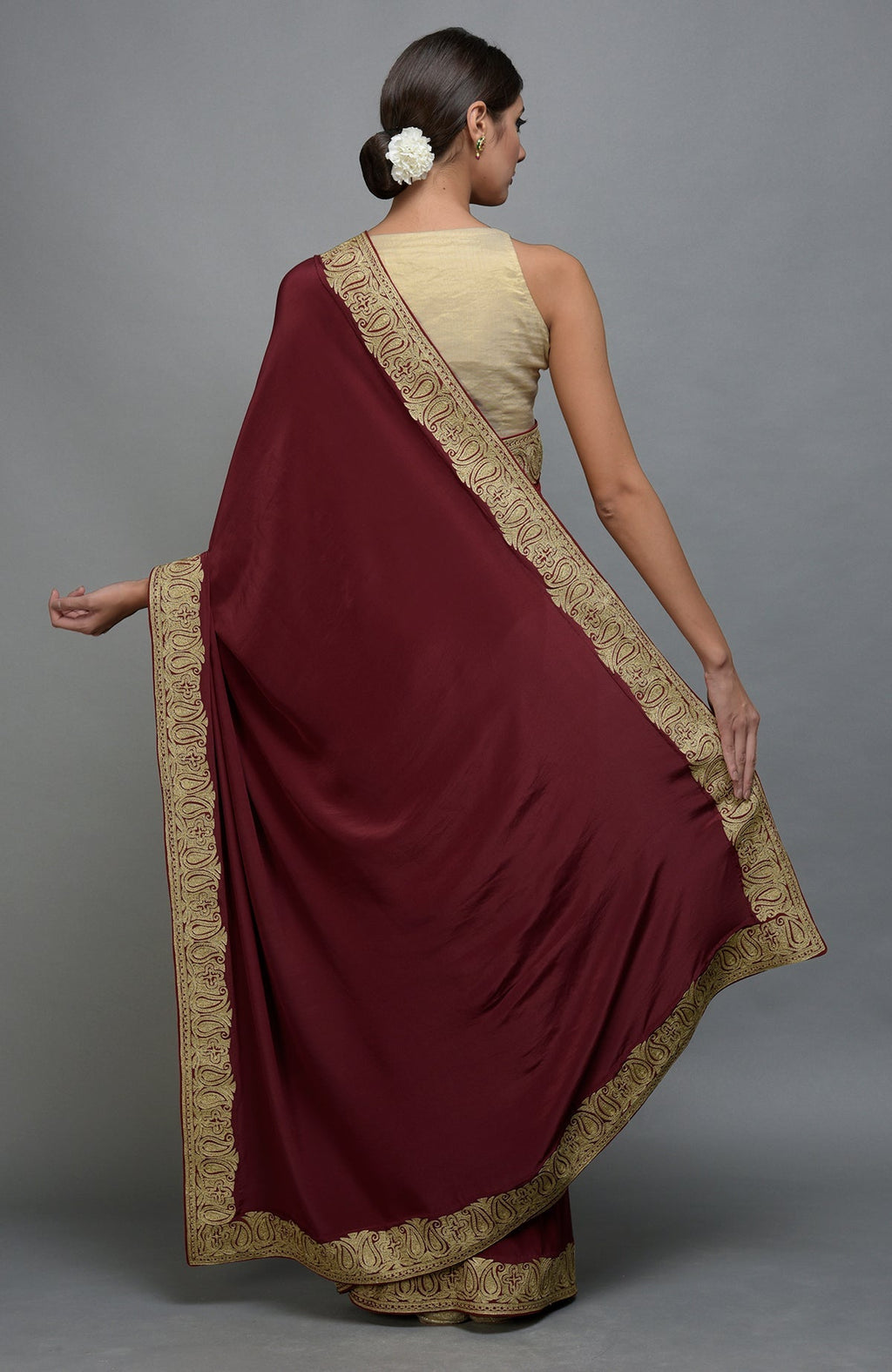 Maroon saree with gold paisley embroidery and a gold blouse.