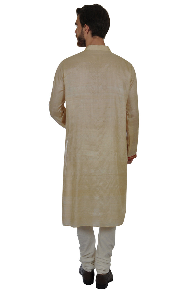 Rear view of a man wearing a beige pure kosa silk kurta and white churidar.