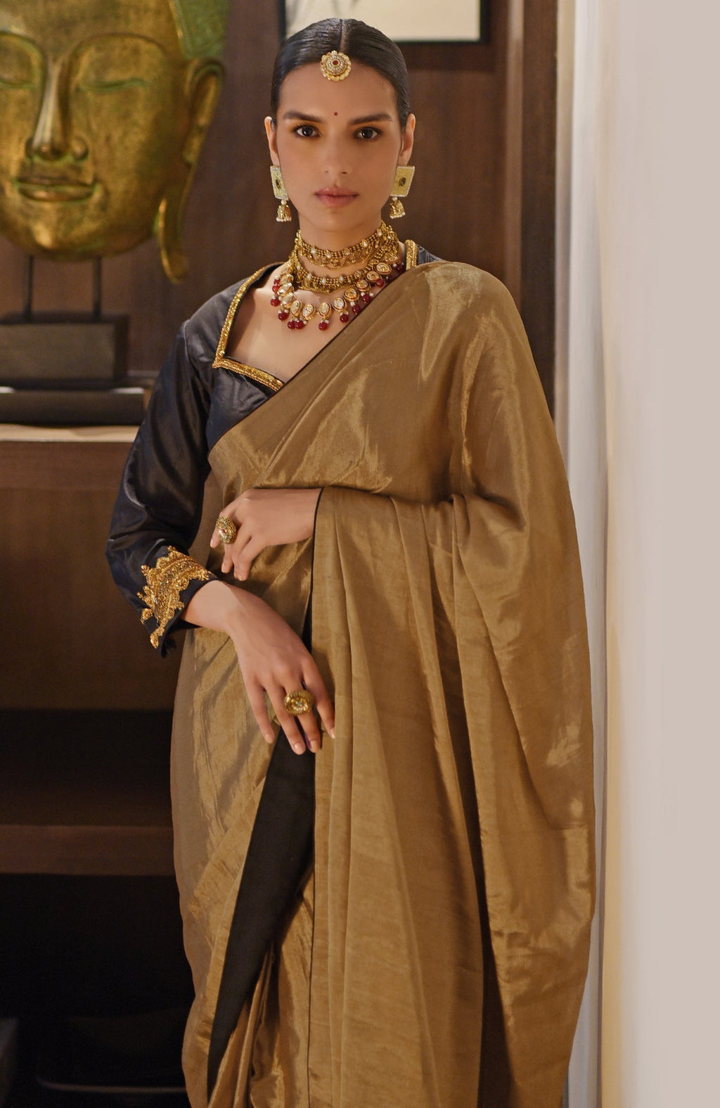 Gold tissue saree with a black zardozi embroidered blouse.