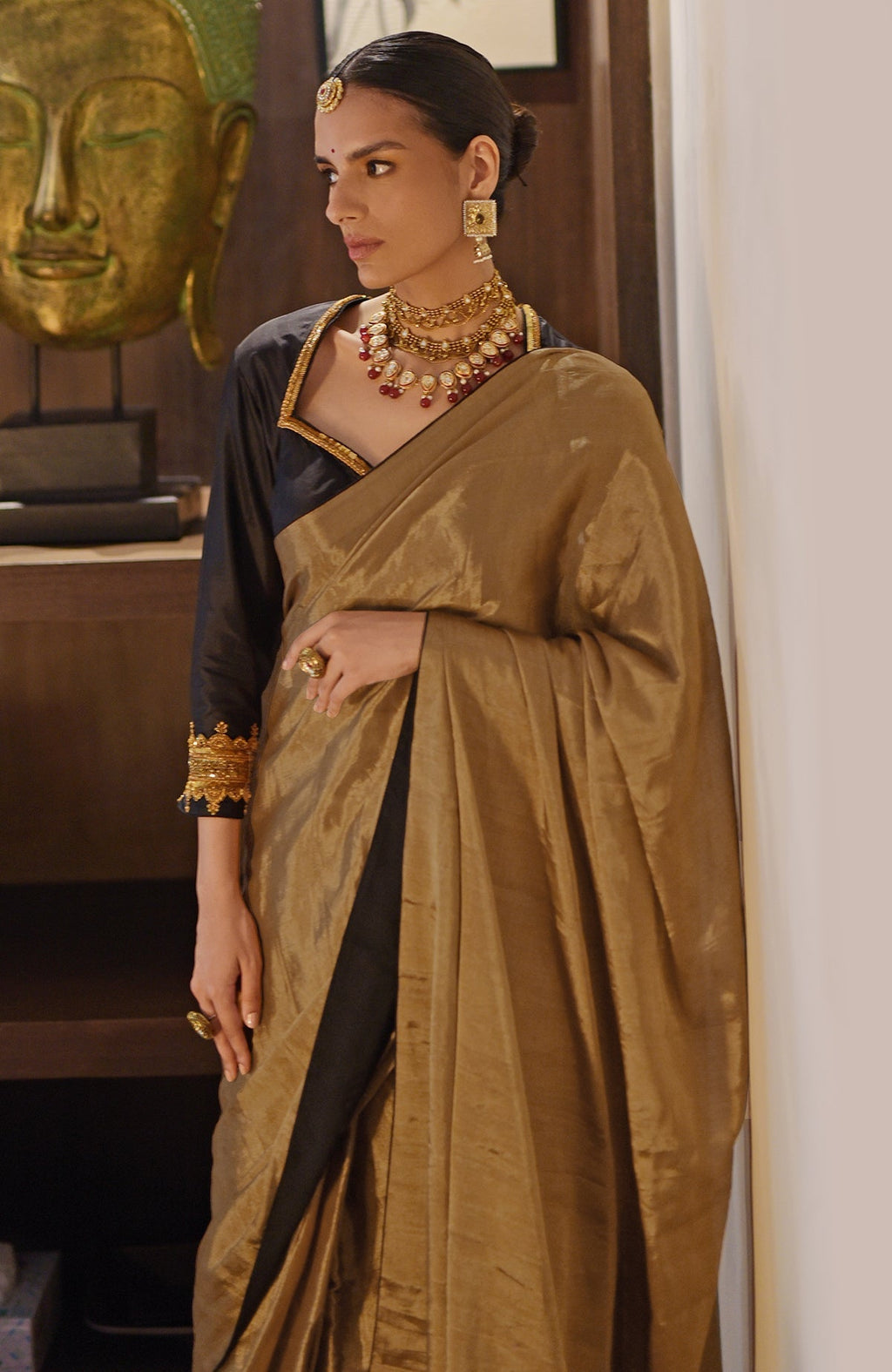 Gold tissue saree with a black zardozi embroidered blouse.