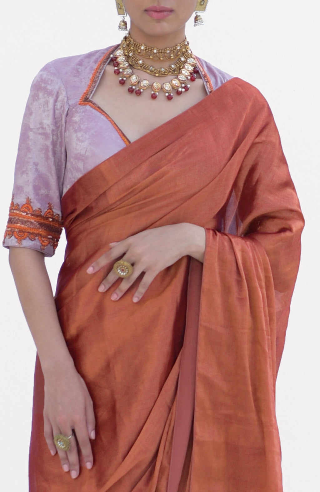 A woman models a pre-stitched copper tissue saree with a zardozi embroidered blouse.
