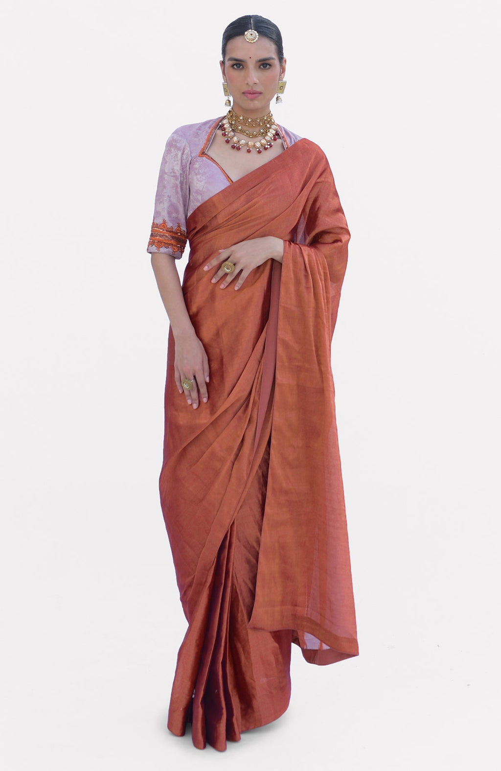 A woman models a pre-stitched copper tissue saree with a zardozi embroidered blouse.