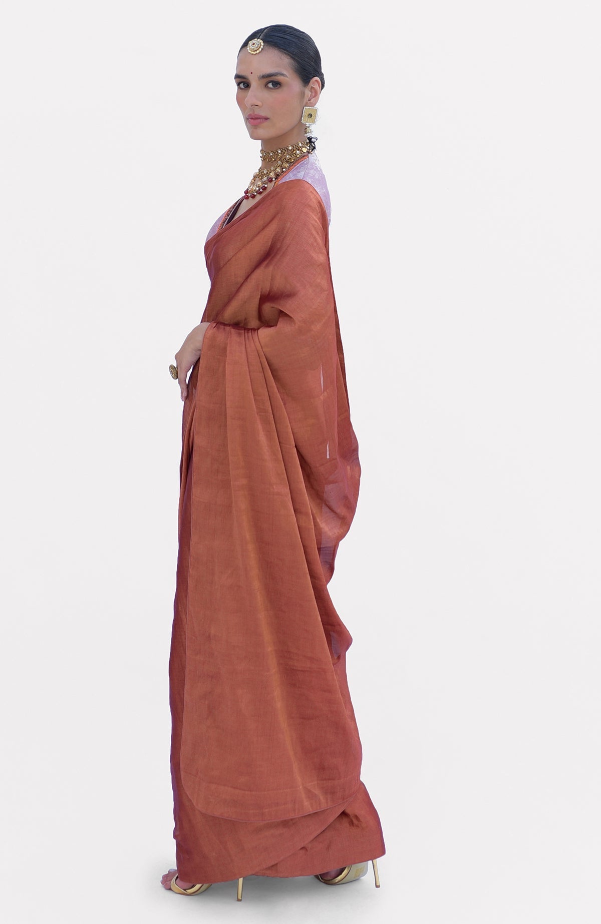 A woman models a pre-stitched copper pure tissue saree with a zardozi embroidered blouse.
