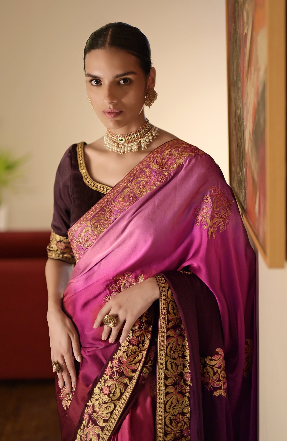 A woman models a wine-pink ombre Kashidakari embroidered saree with a wine blouse.