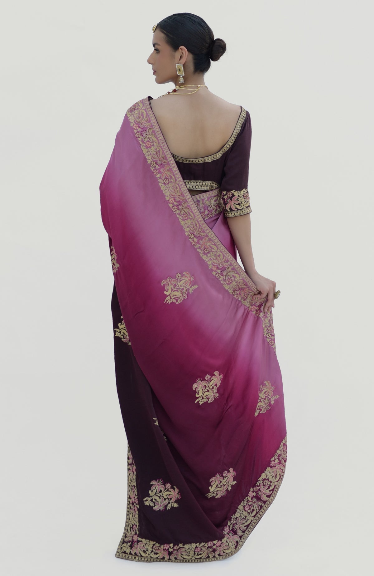 A woman from behind wears a wine-pink ombre Kashidakari embroidered saree set.
