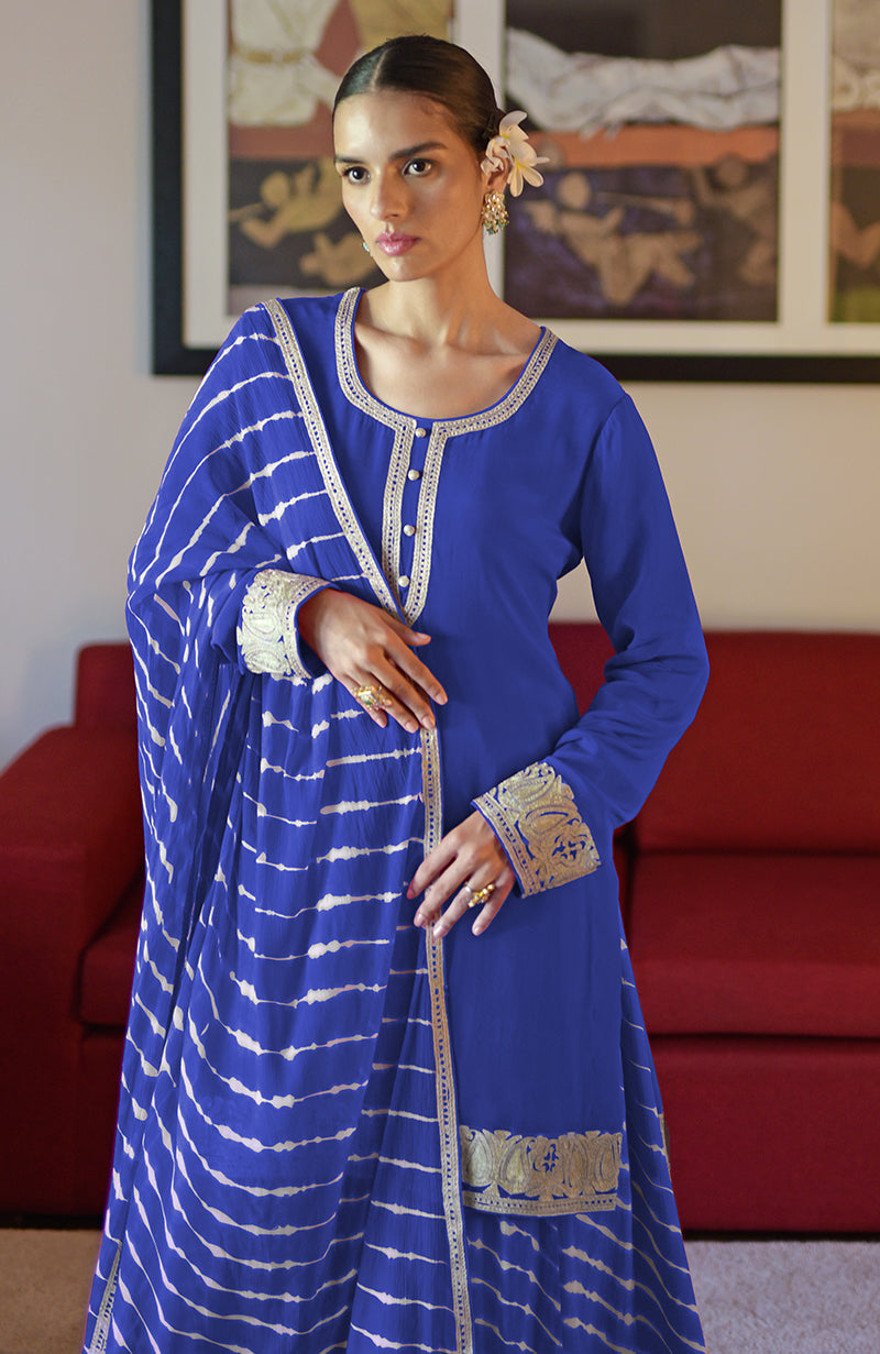 A woman models a royal blue leheriya handcrafted tie-dye and Kashmiri tilla sharara set.
