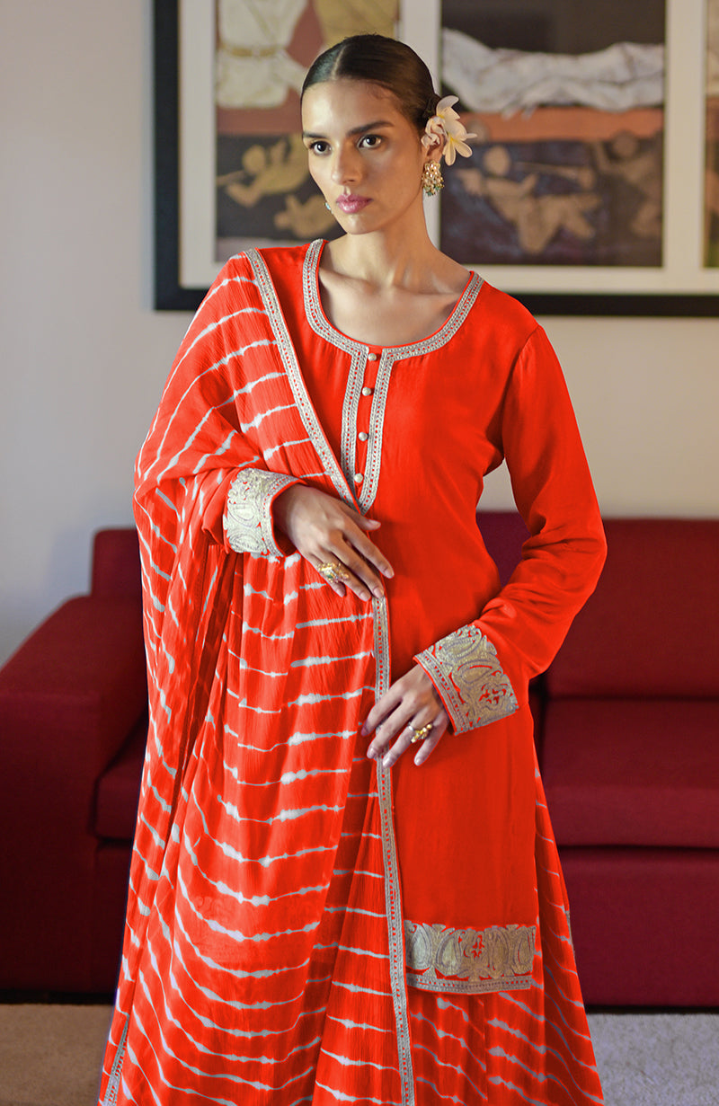 Tomato red Leheriya sharara set with Kashmiri tilla embroidery.