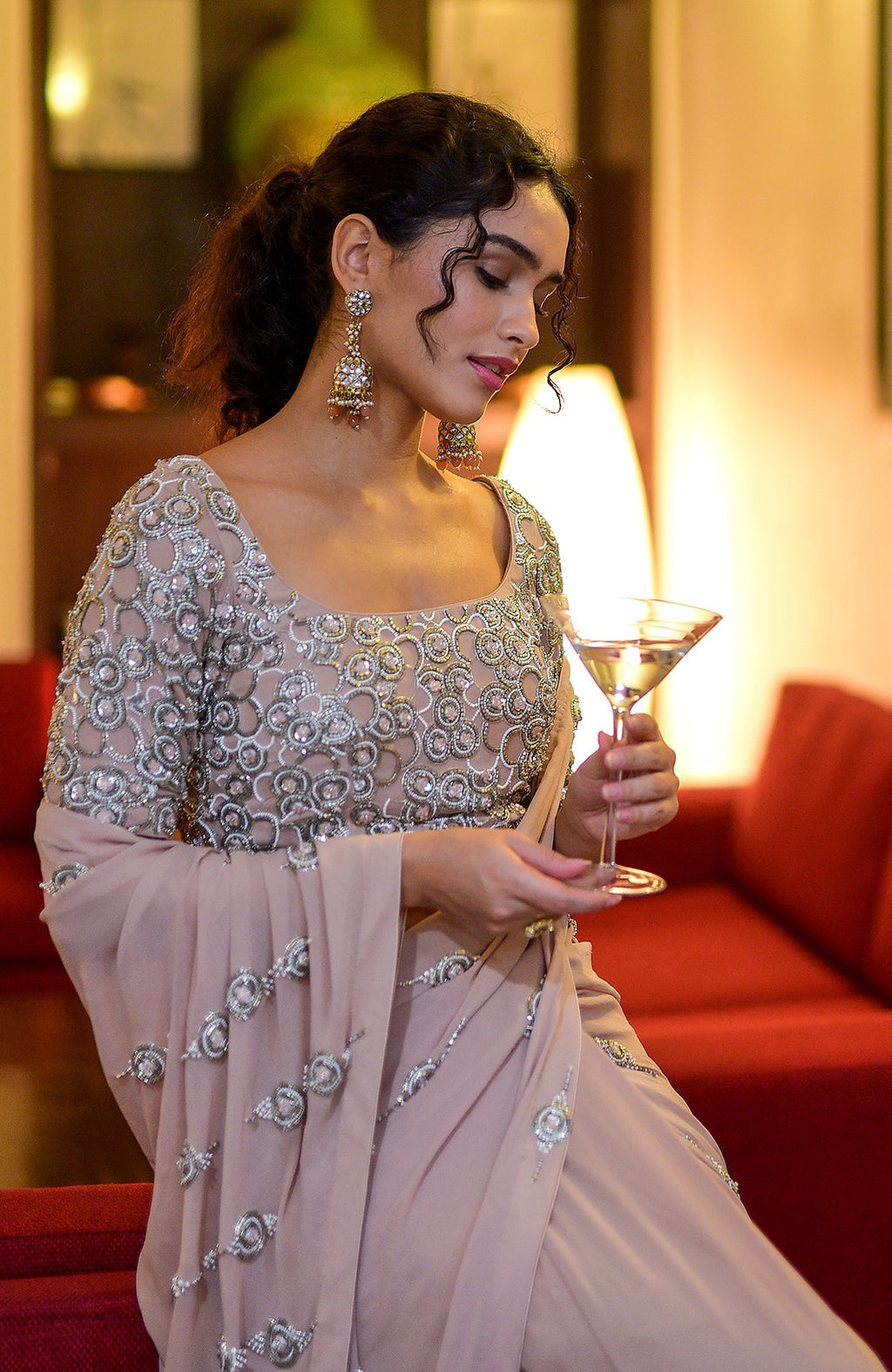 Woman in a nude hand-embroidered pre-draped saree with a matching blouse.