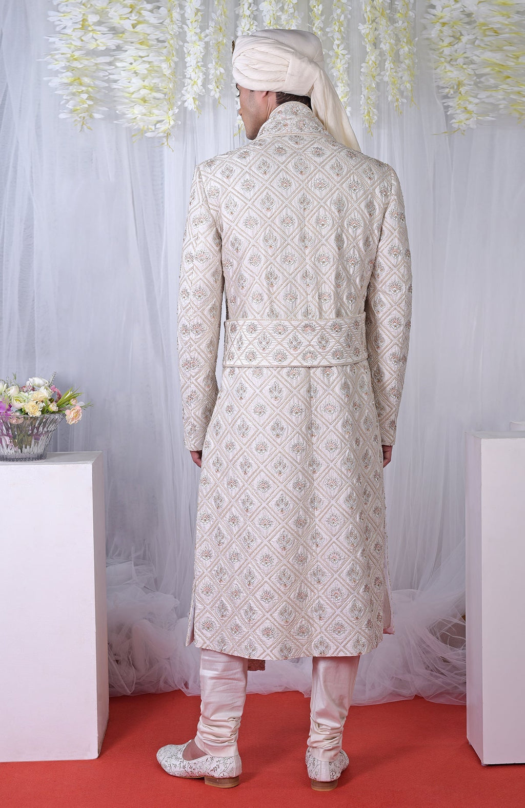 Rear view of an ivory geometric floral embroidered sherwani set.