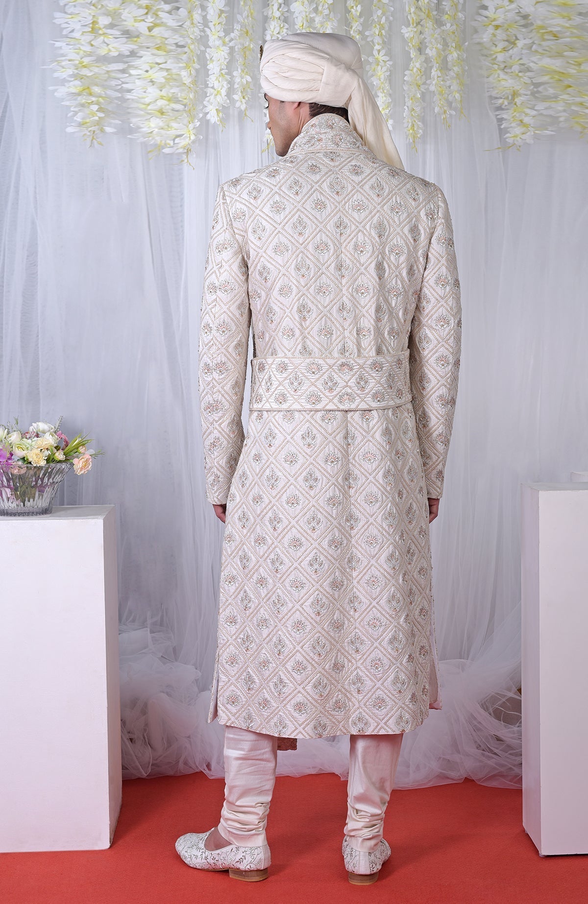 Rear view of an ivory geometric floral embroidered sherwani set.