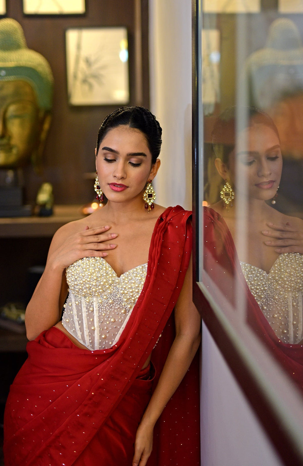 White hand-embroidered corset with a red saree featuring gold sprinkle work.