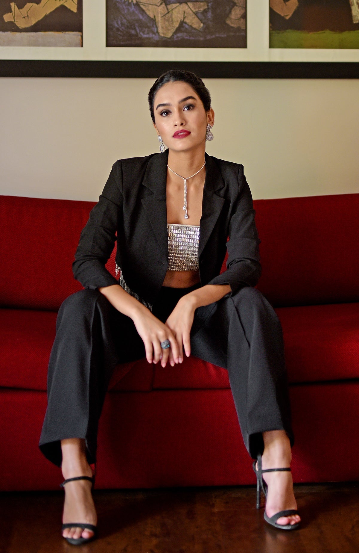 A woman models a diamante crystal hand-embroidered bustier and blazer set with black pants.