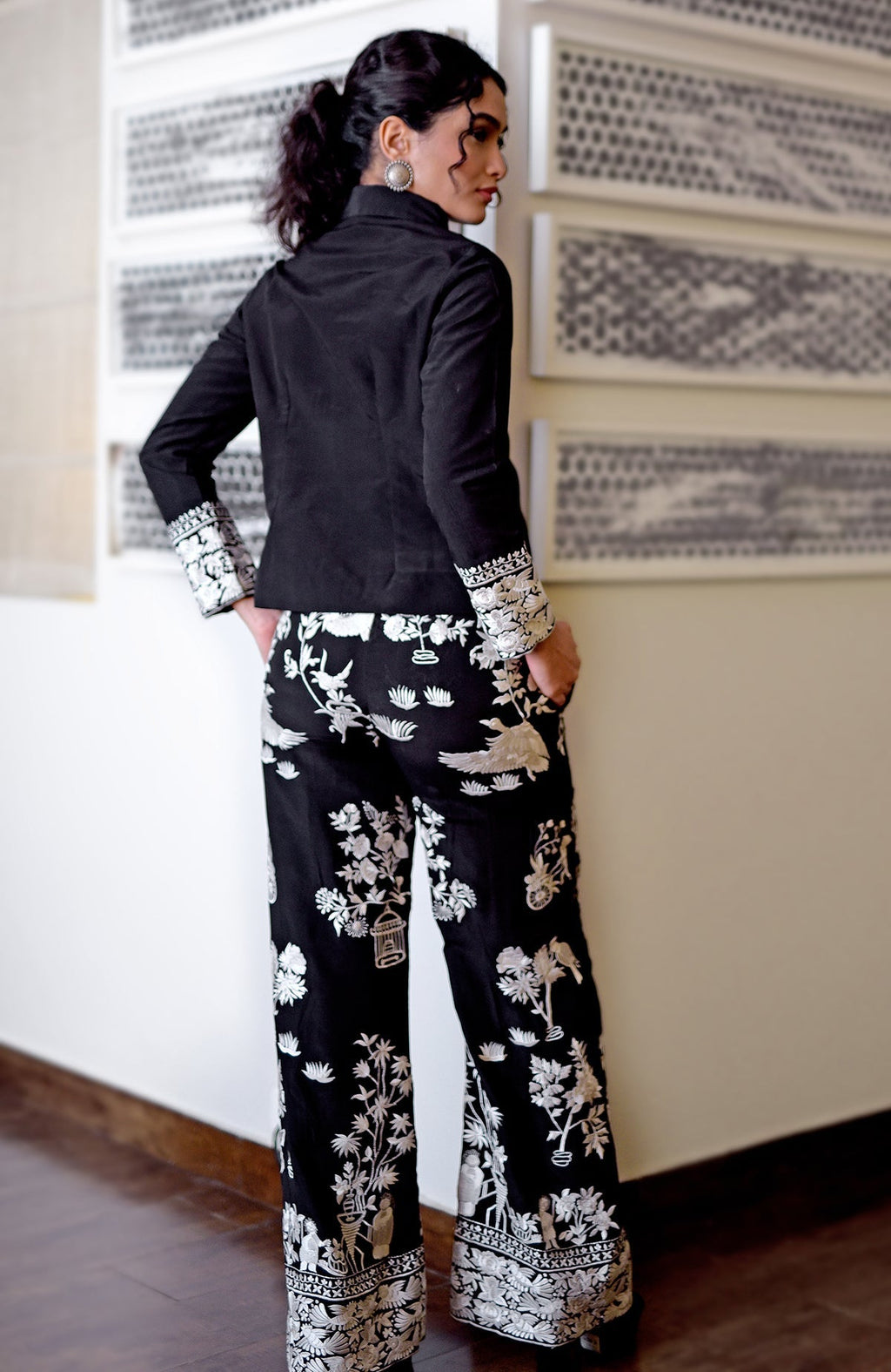 A woman models a black Parsi Gara embroidered co-ord set with a short top and pants.