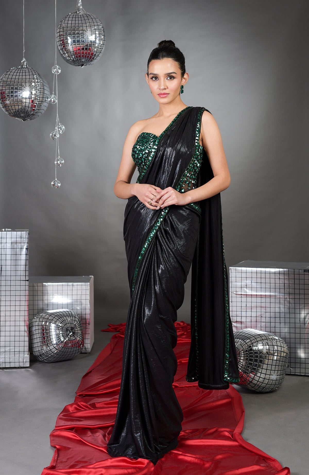 A woman models an Esmeralda hand-embroidered corset and black saree set.