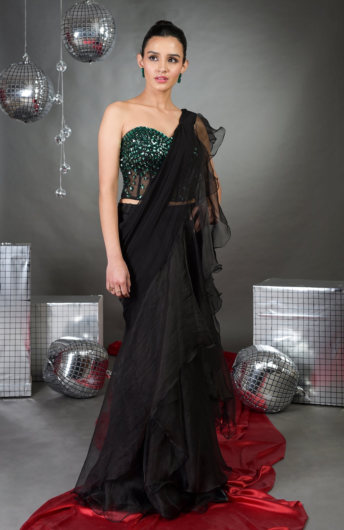 A woman models an Esmeralda hand-embroidered corset and ruffled saree set.