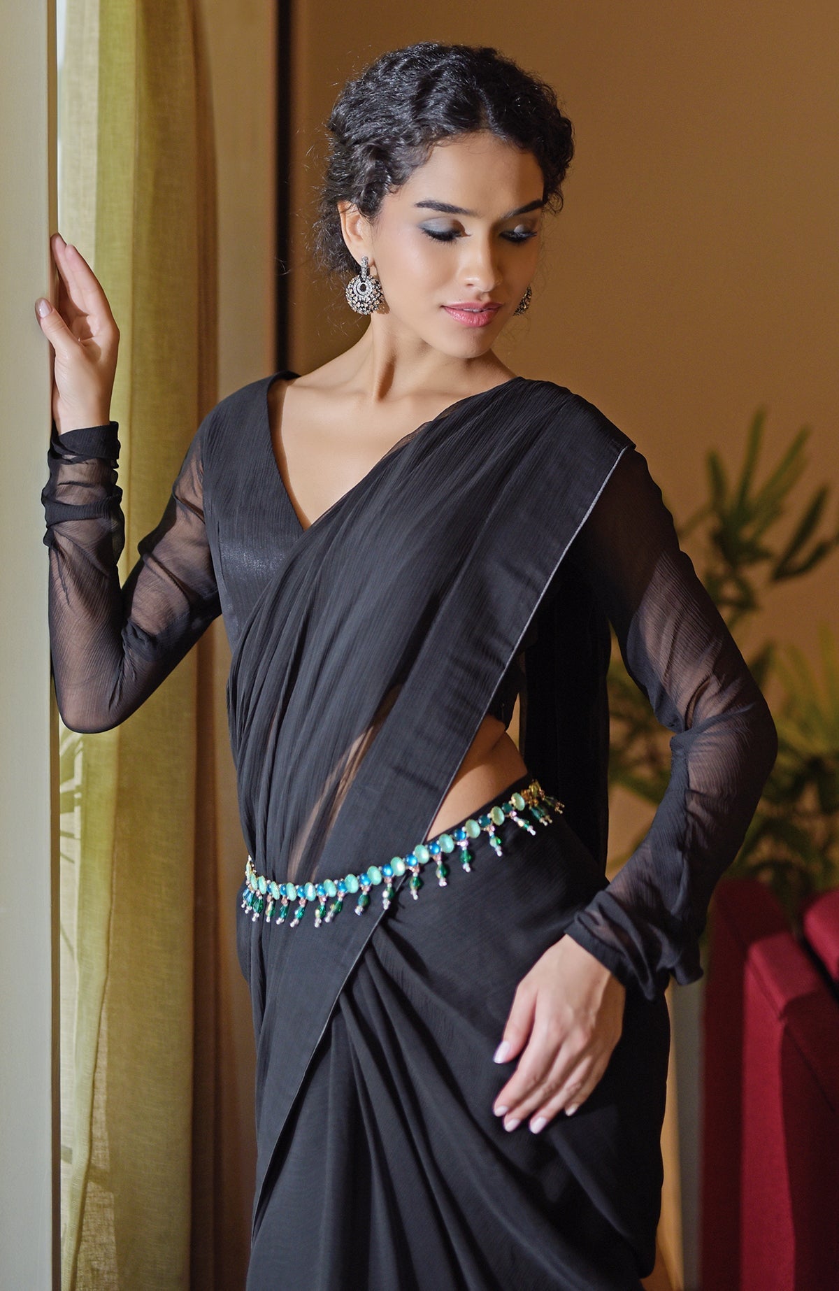 Black chiffon saree with a green and blue jeweled crystal belt.
