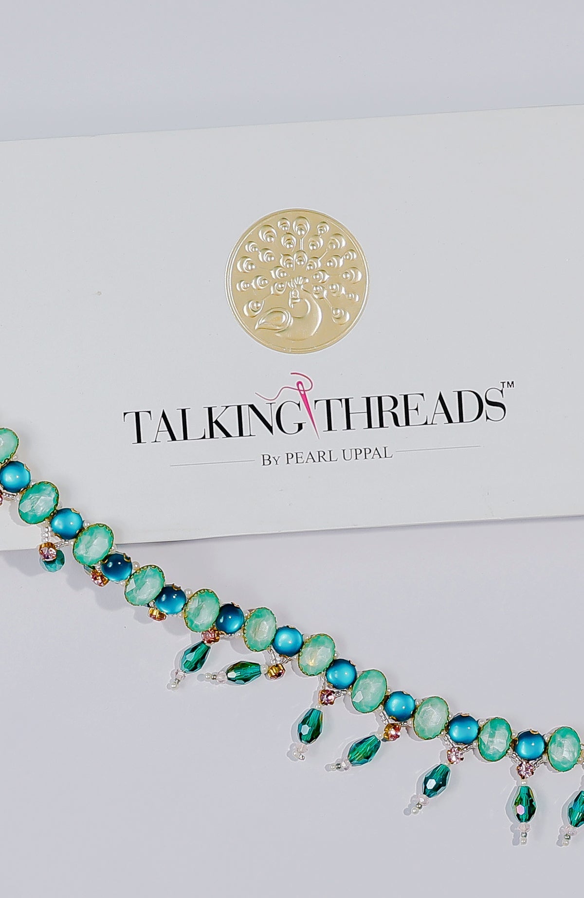 Green and blue jeweled crystal belt with dangling emerald-green stones.
