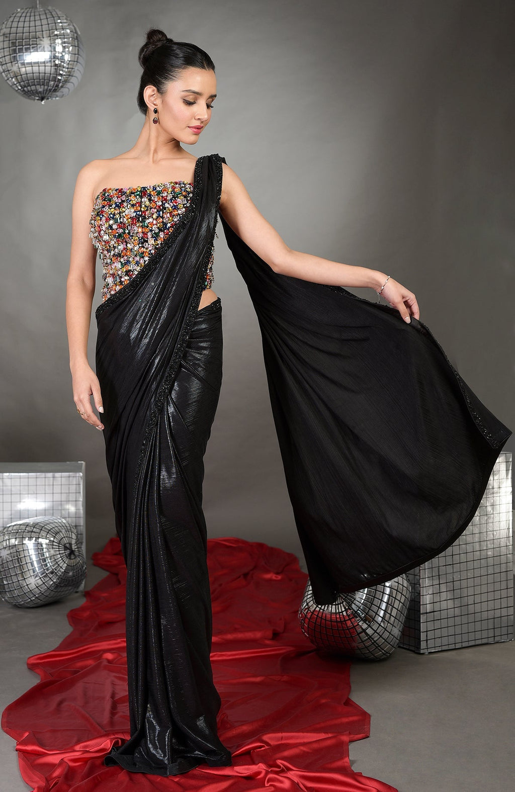 A woman models a black saree with a colorful embroidered strapless corset.
