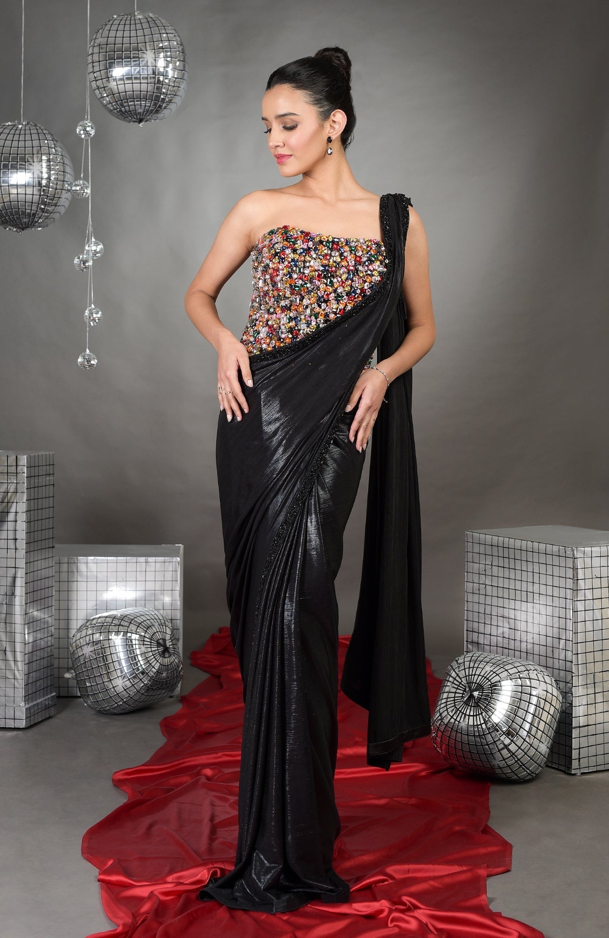Model wears a black saree with a multi-colored crystal embroidered corset.
