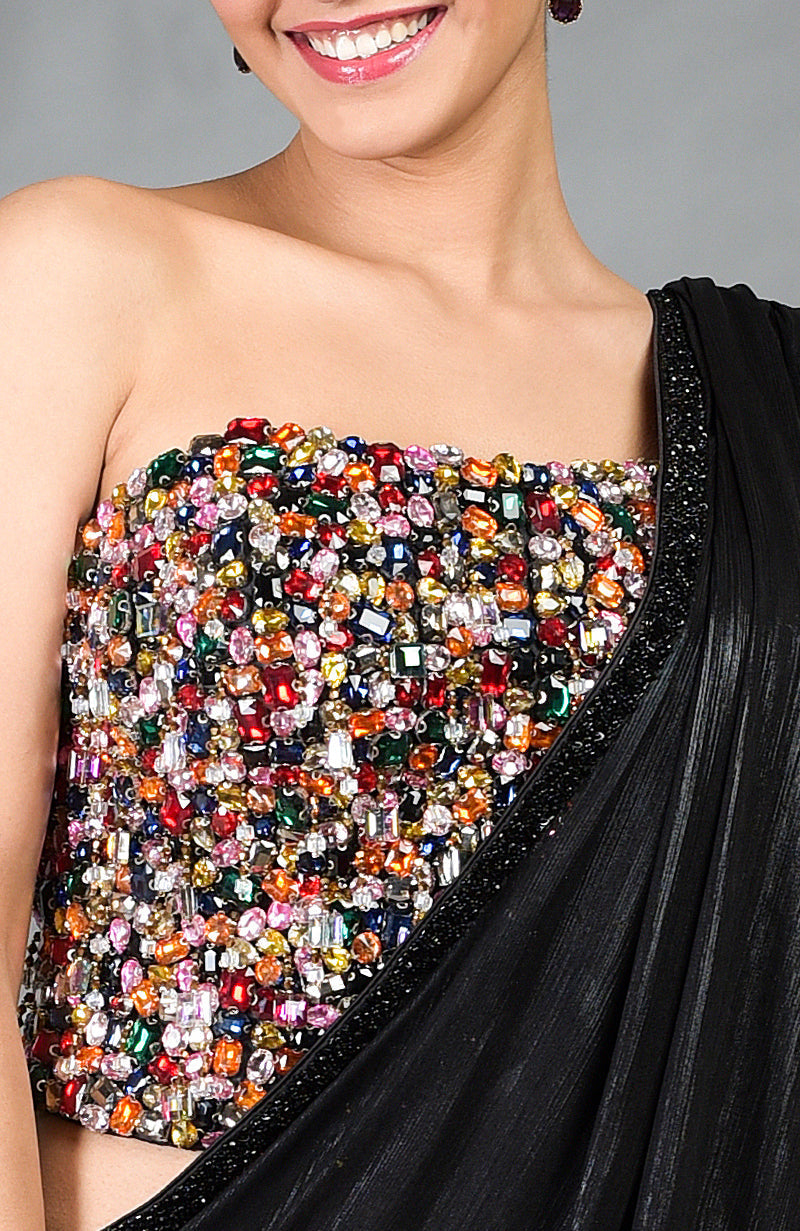 A woman models a black saree with a colorful, gem-encrusted corset.