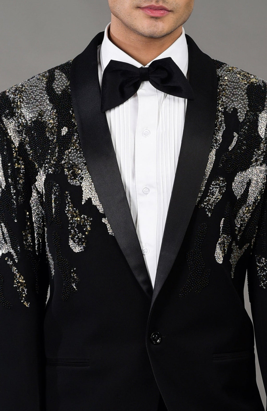 Black tuxedo jacket with a sequined abstract pattern, white shirt, and black bow tie.