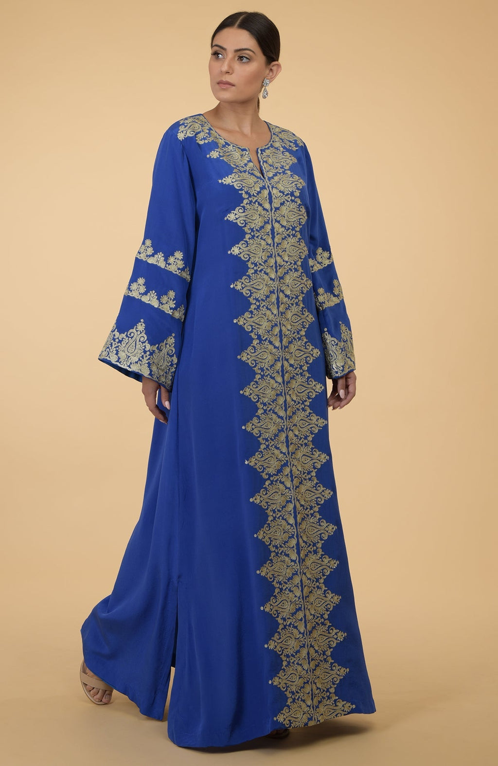 A woman models a cobalt blue kaftan with gold Kashmir embroidery.