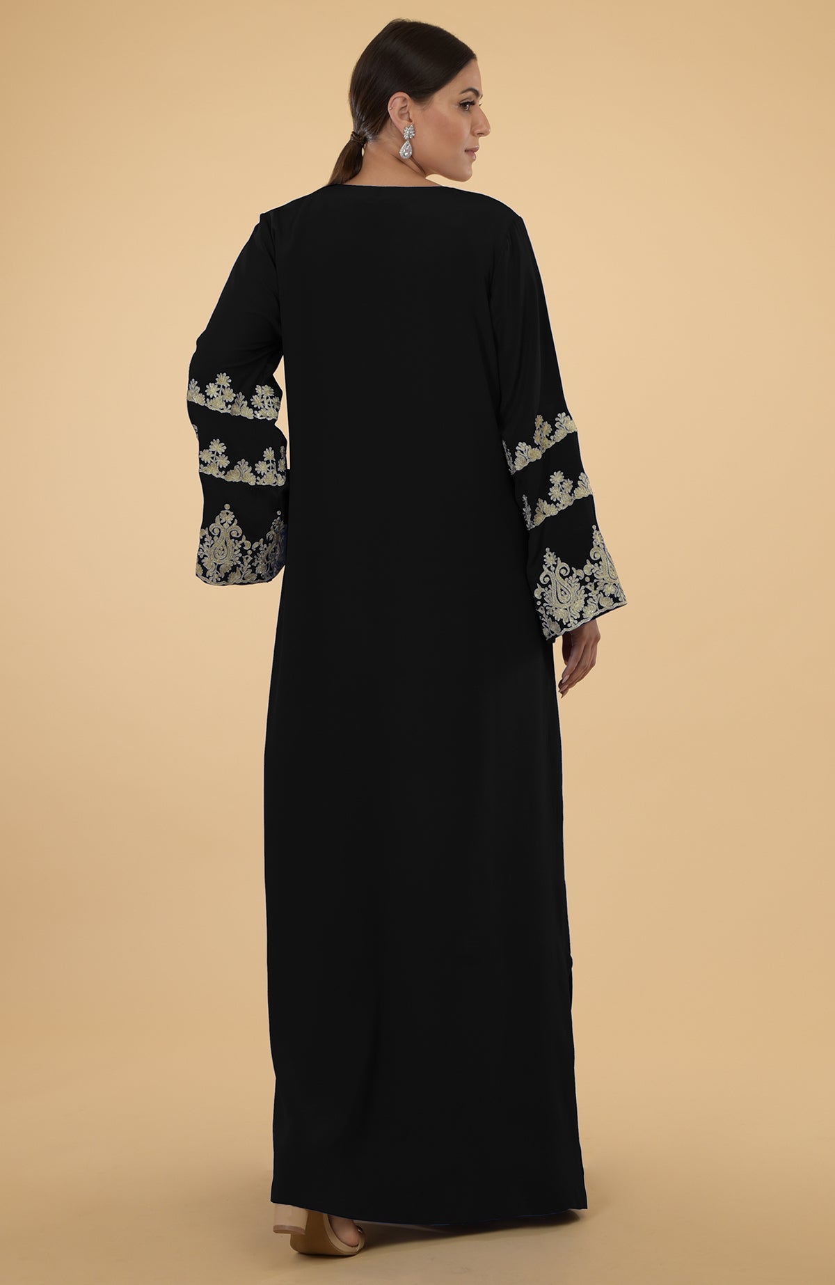 Black kaftan with gold Kashmir embroidery on the bell sleeves.