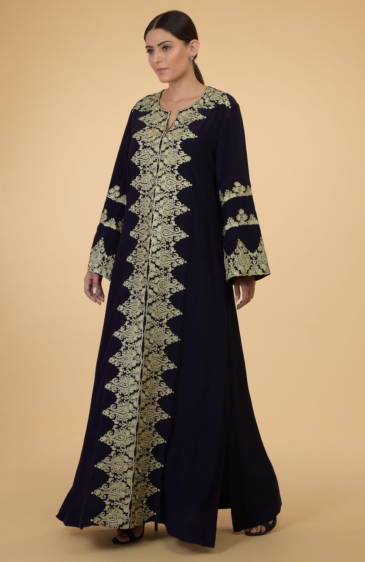 Cobalt blue kaftan with gold Kashmir embroidery, worn by a woman.