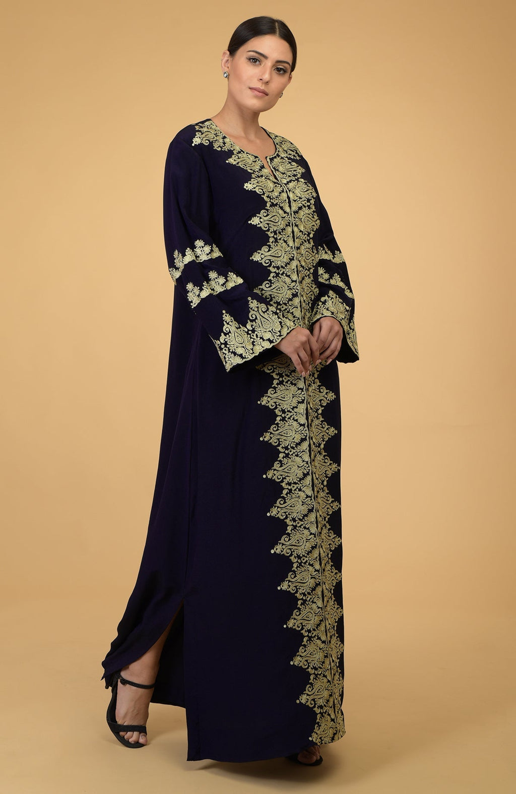 Midnight blue kaftan with gold Kashmir embroidery, worn by a woman.