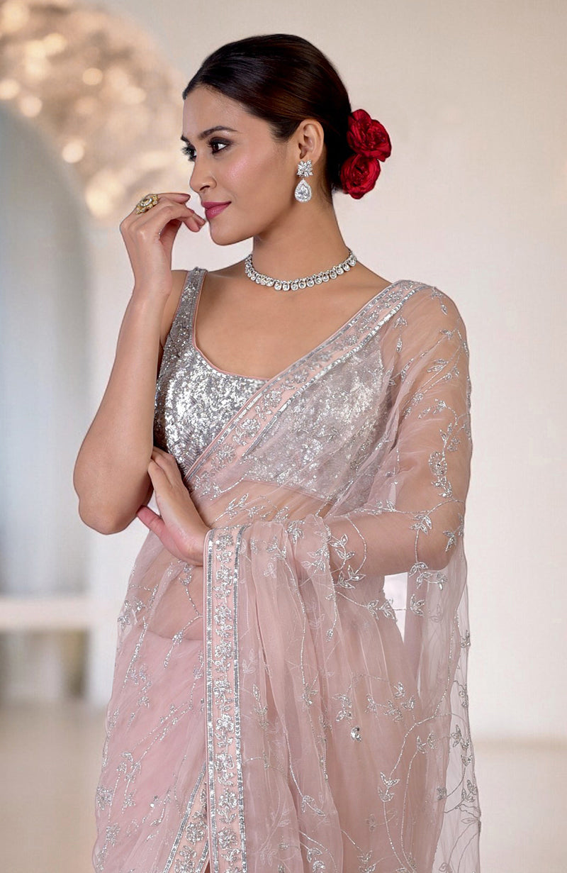 An oyster pink saree with silver beads and sequin zardozi hand embroidery.