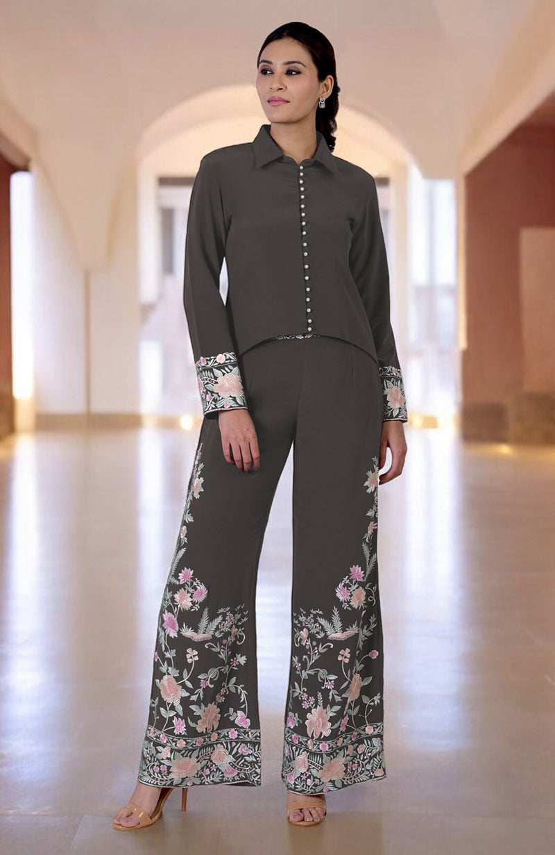 A woman models a charcoal grey Parsi Gara embroidered co-ord set.