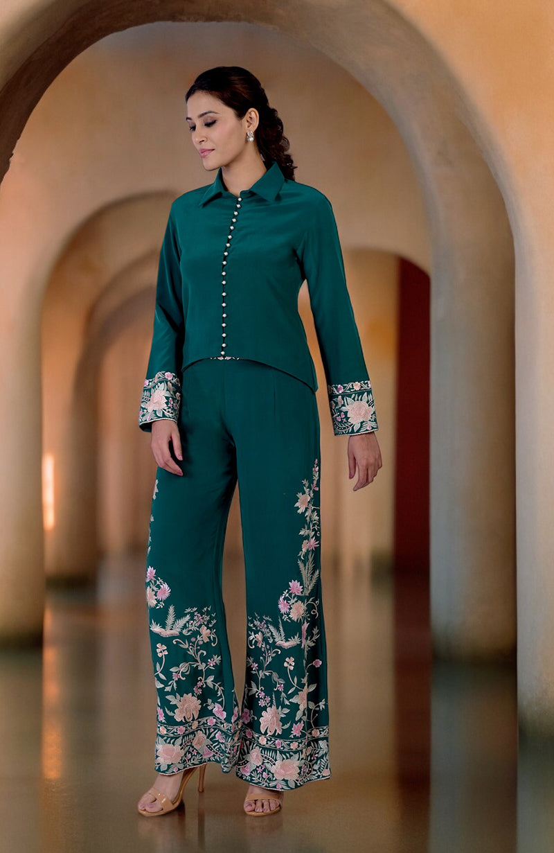 A woman models a green Parsi Gara embroidered co-ord set with a high-low top.