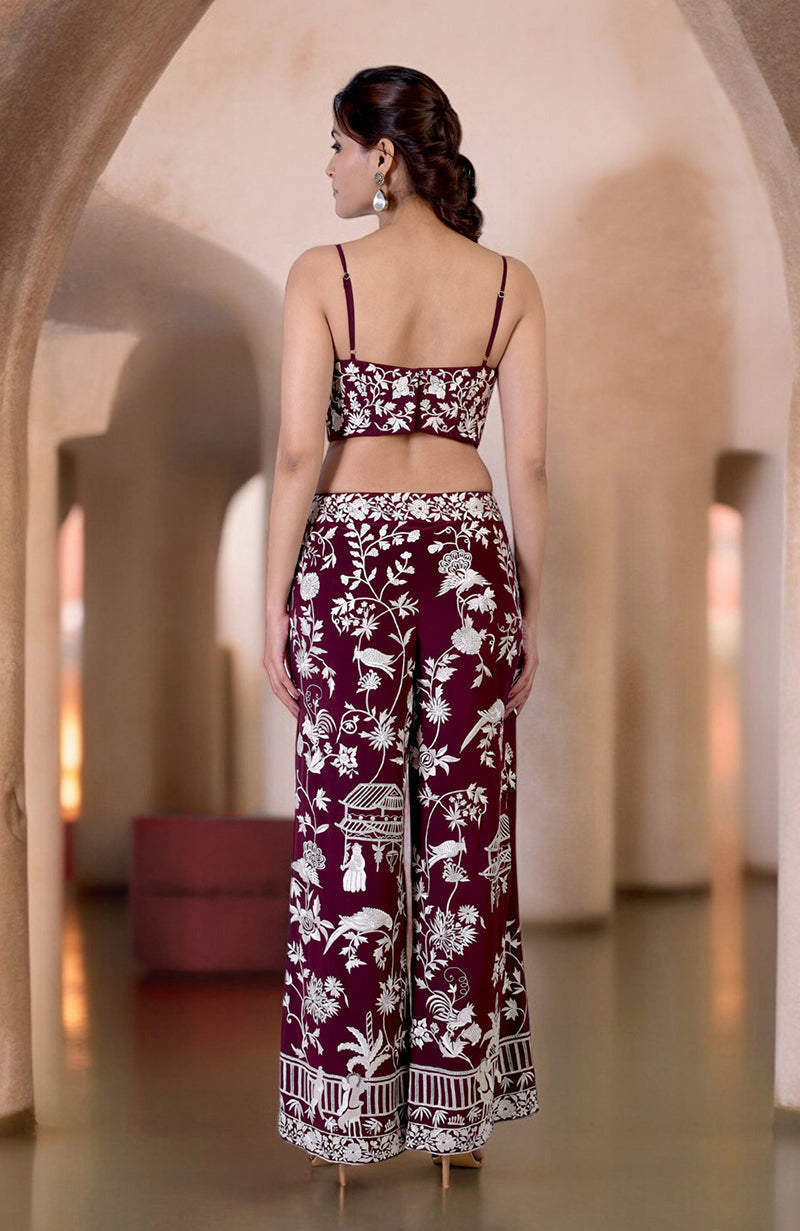 A woman from behind wears a ruby wine Parsi Gara embroidered co-ord set.