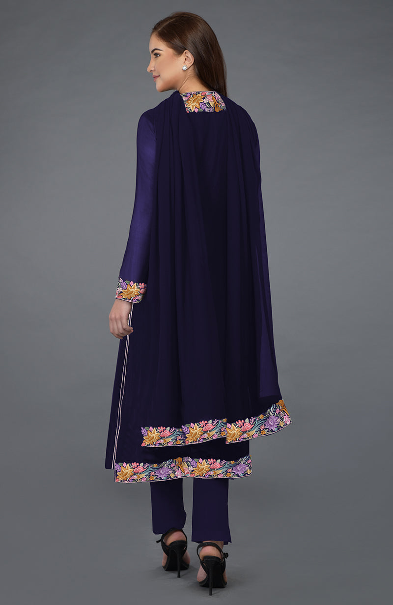 Woman in a navy blue Parsi Gara embroidered overlay suit with floral patterns.