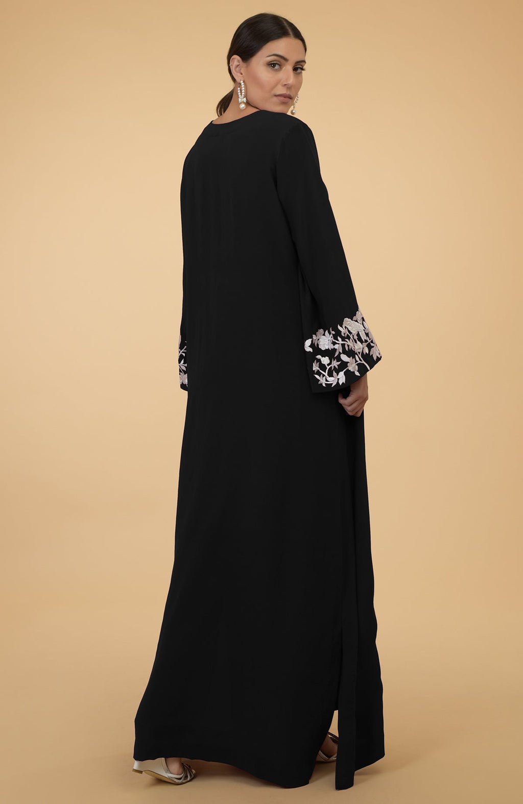 Black silk crepe kaftan with ivory floral and bird embroidery on the sleeves.