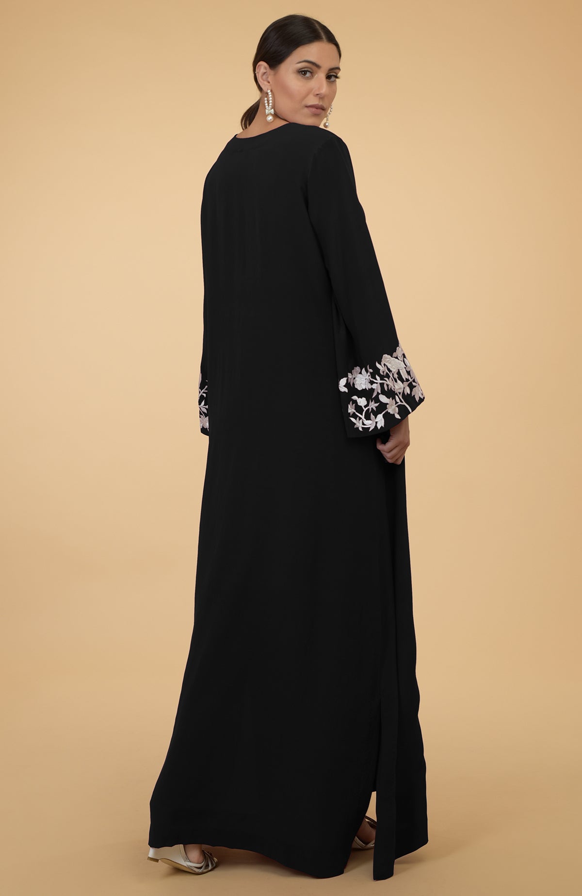 Black silk crepe kaftan with ivory floral and bird embroidery on the sleeves.