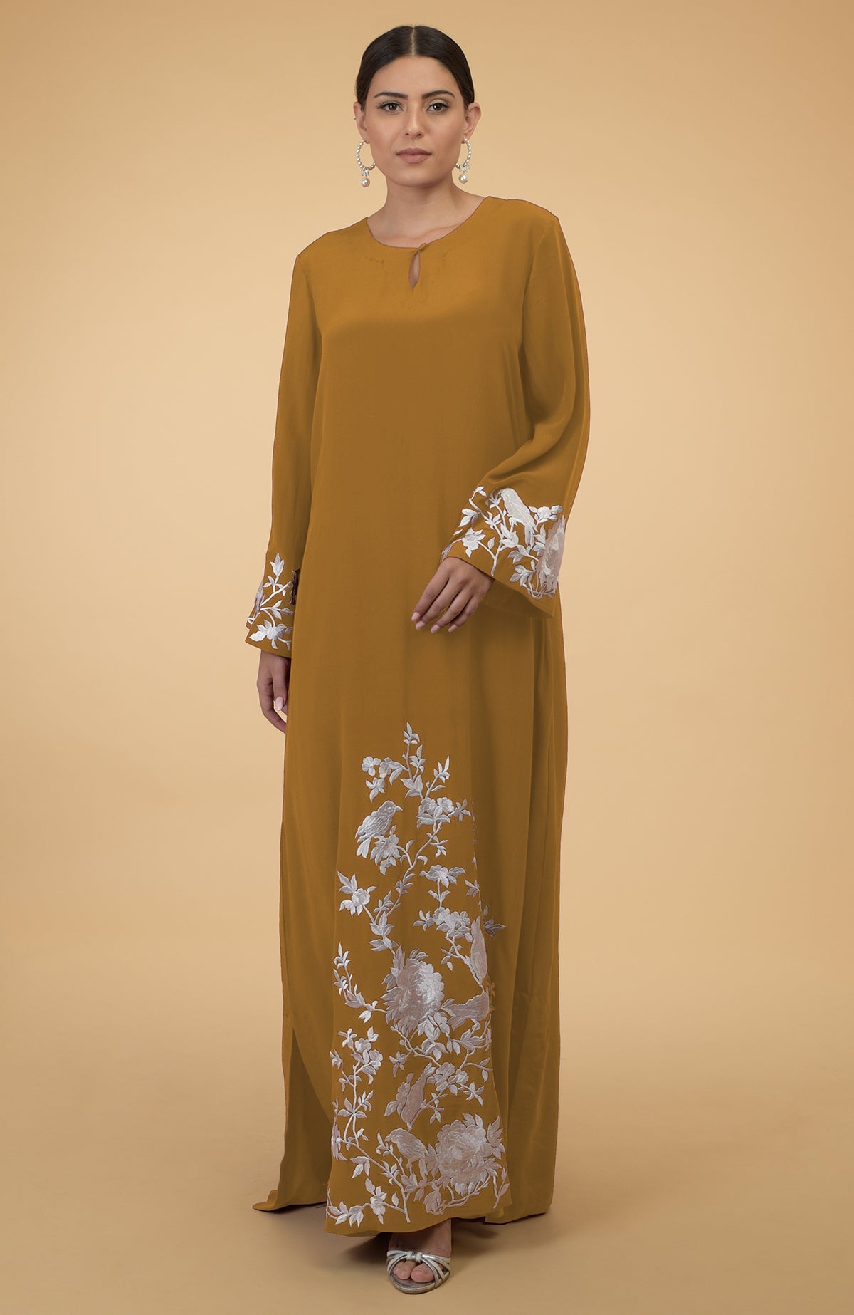 Muted mustard kaftan with floral and bird embroidery on sleeves and hem.