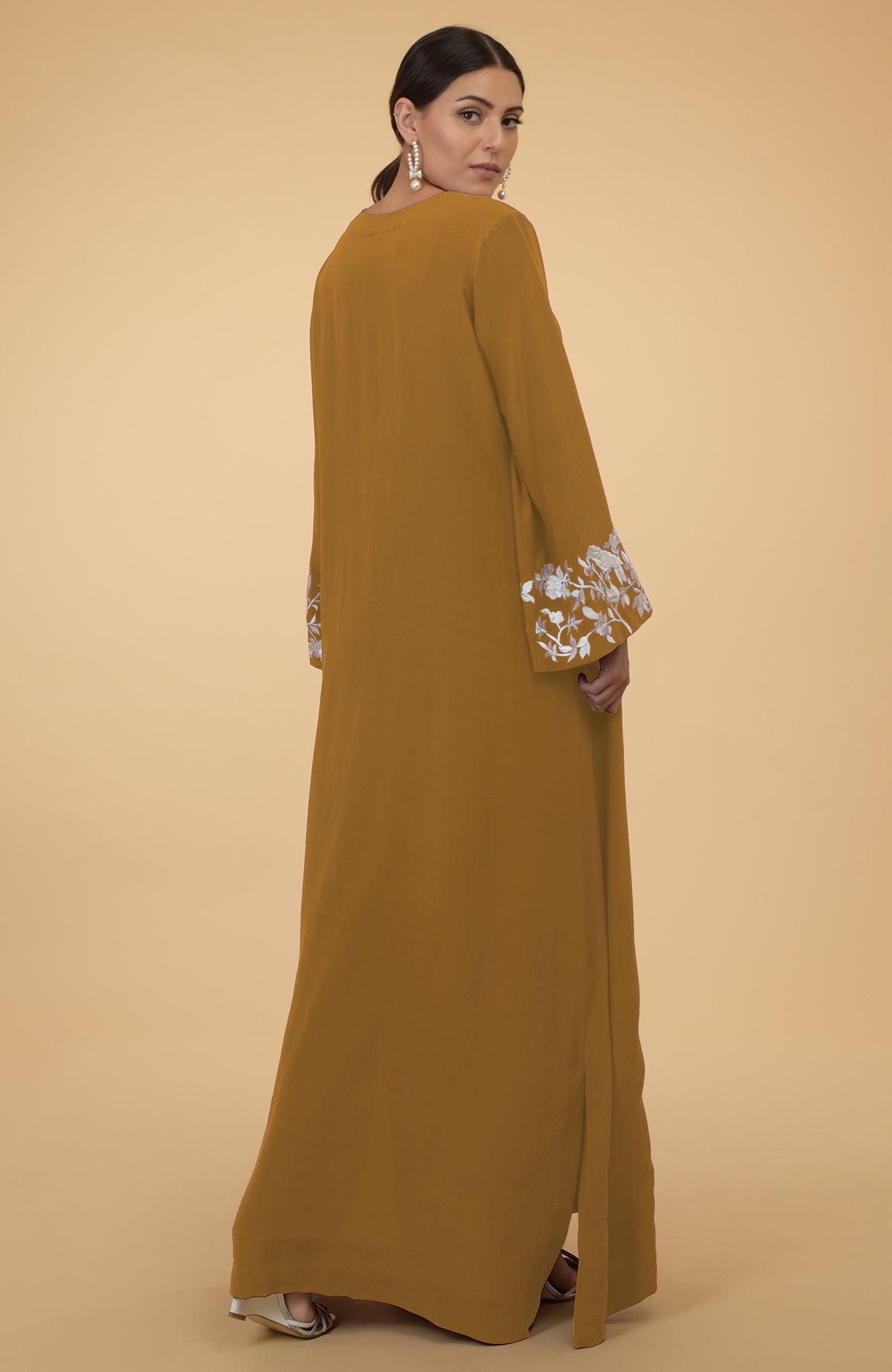 Muted mustard silk crepe kaftan with floral and bird embroidery on the sleeves.