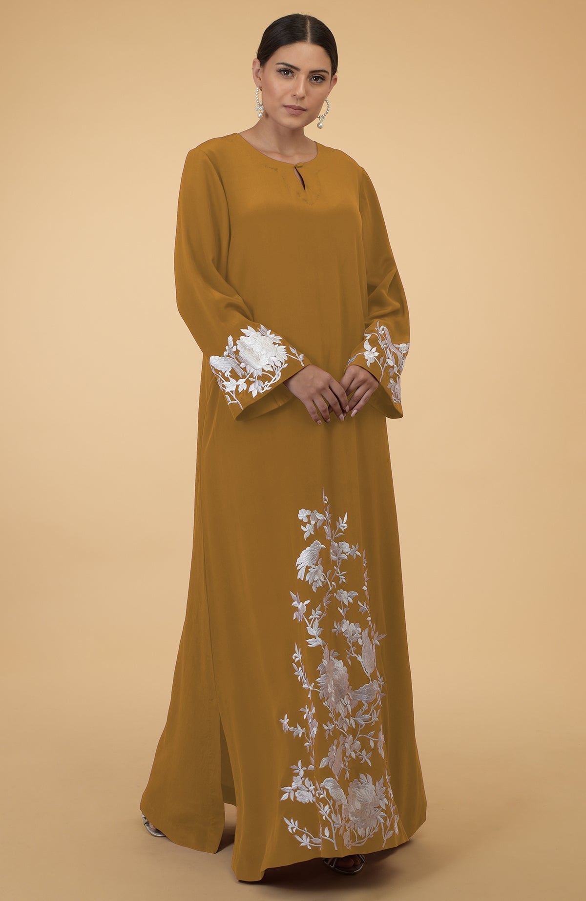 Muted mustard kaftan with white floral and bird embroidery.