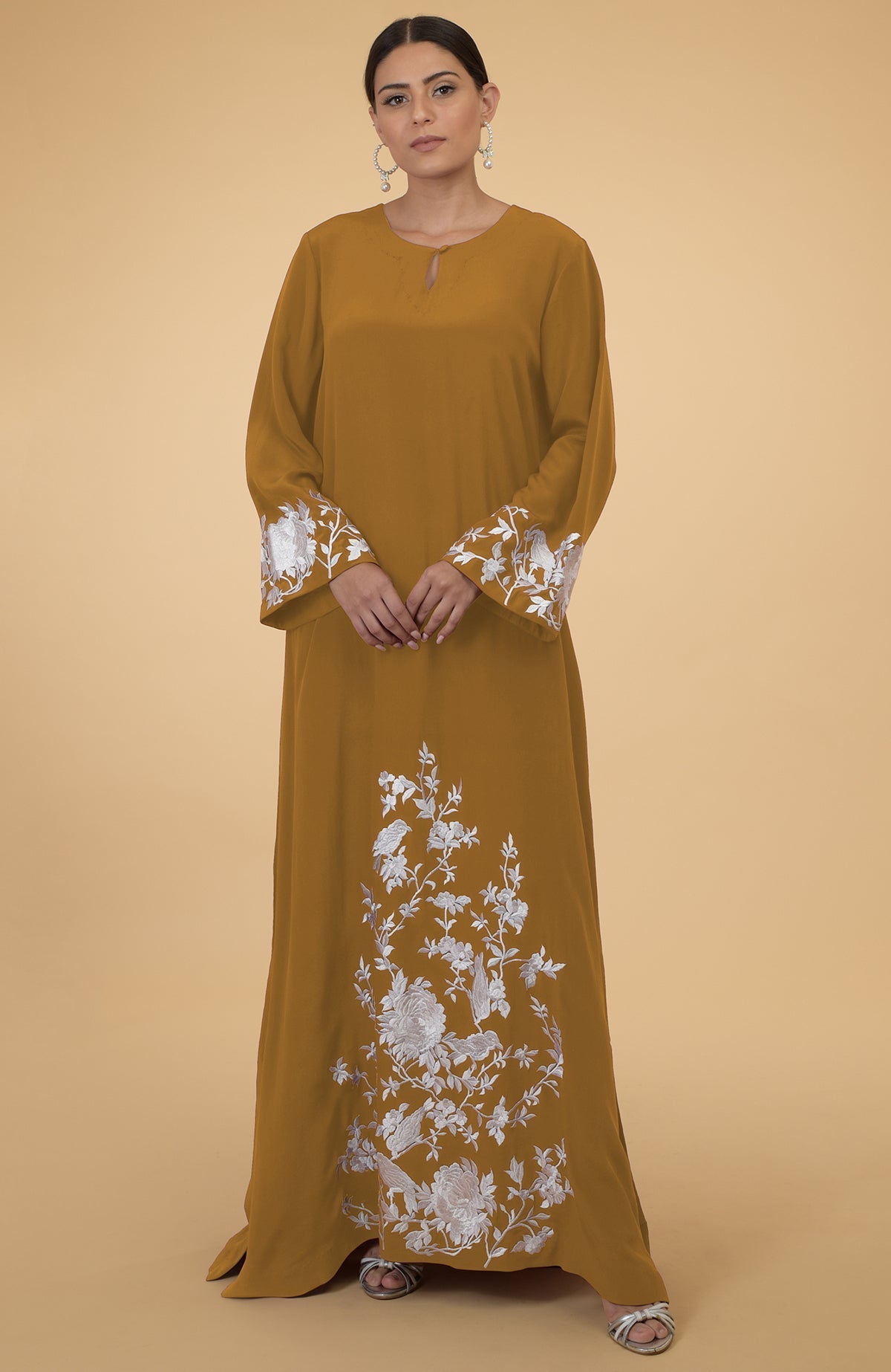 Muted mustard silk crepe kaftan with white floral and bird embroidery.