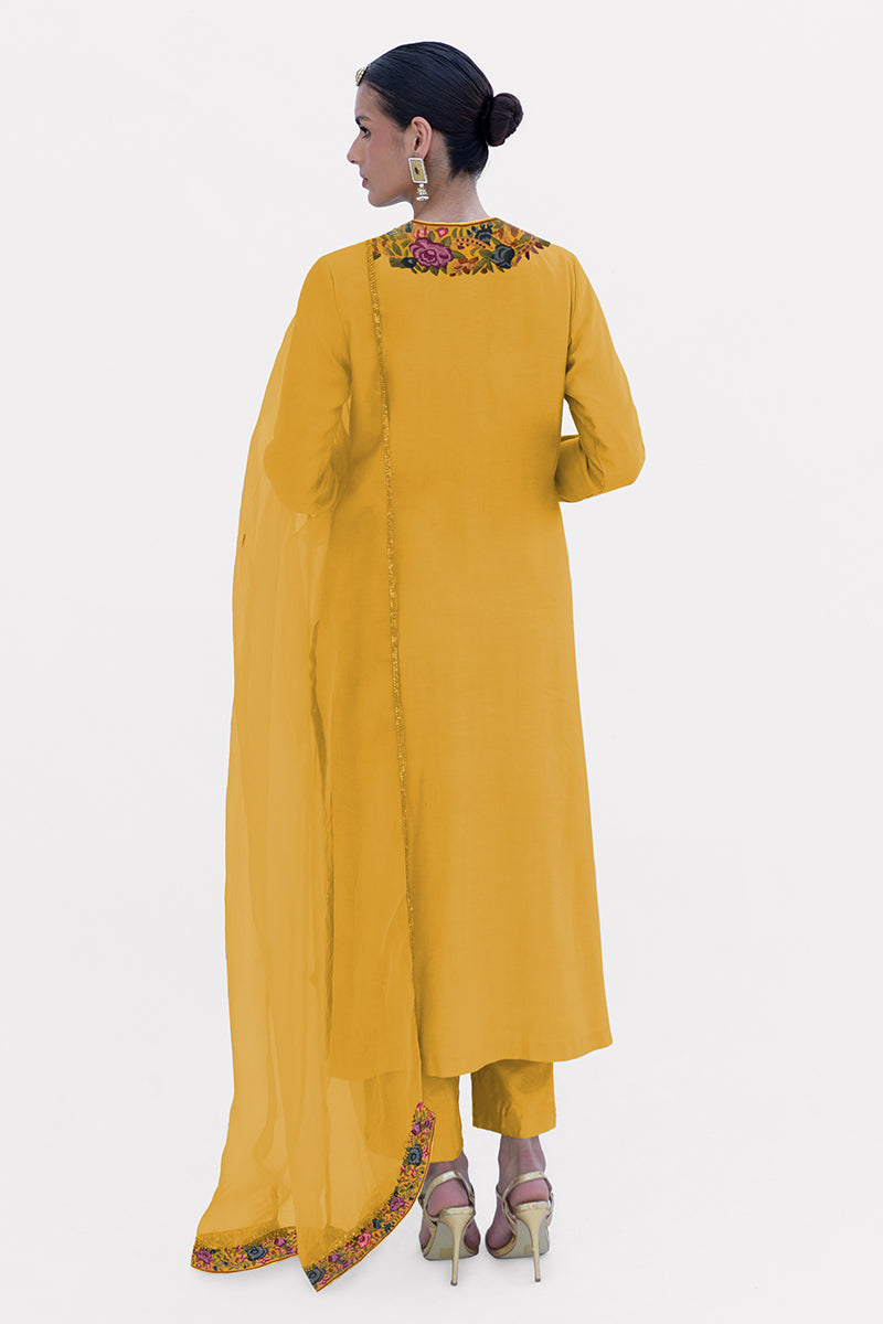 A woman models a calendula yellow Parsi Gara embroidered kurta set with a matching dupatta.