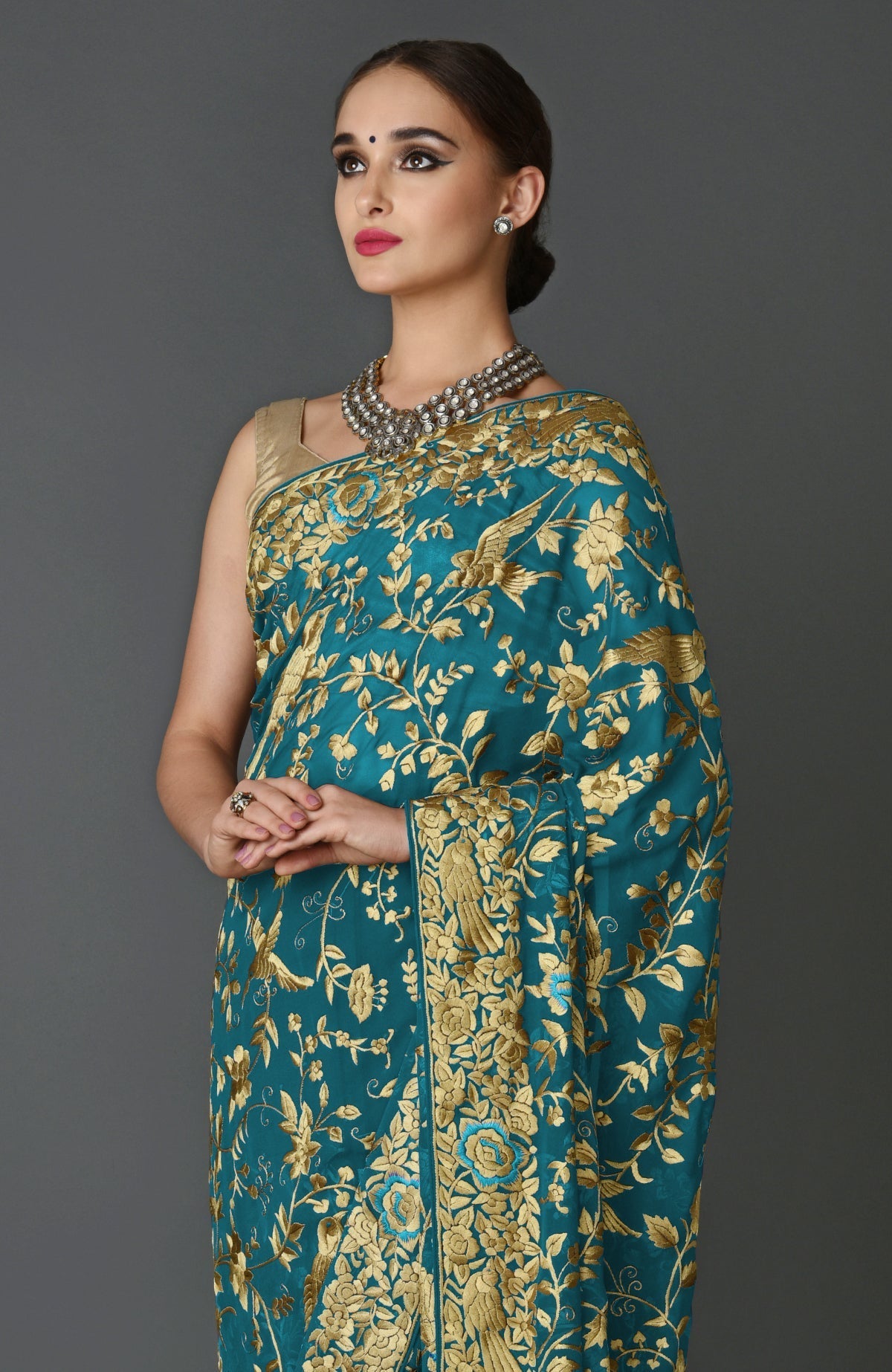 Teal blue georgette saree with beige silk bird and floral hand embroidery and matching blouse piece