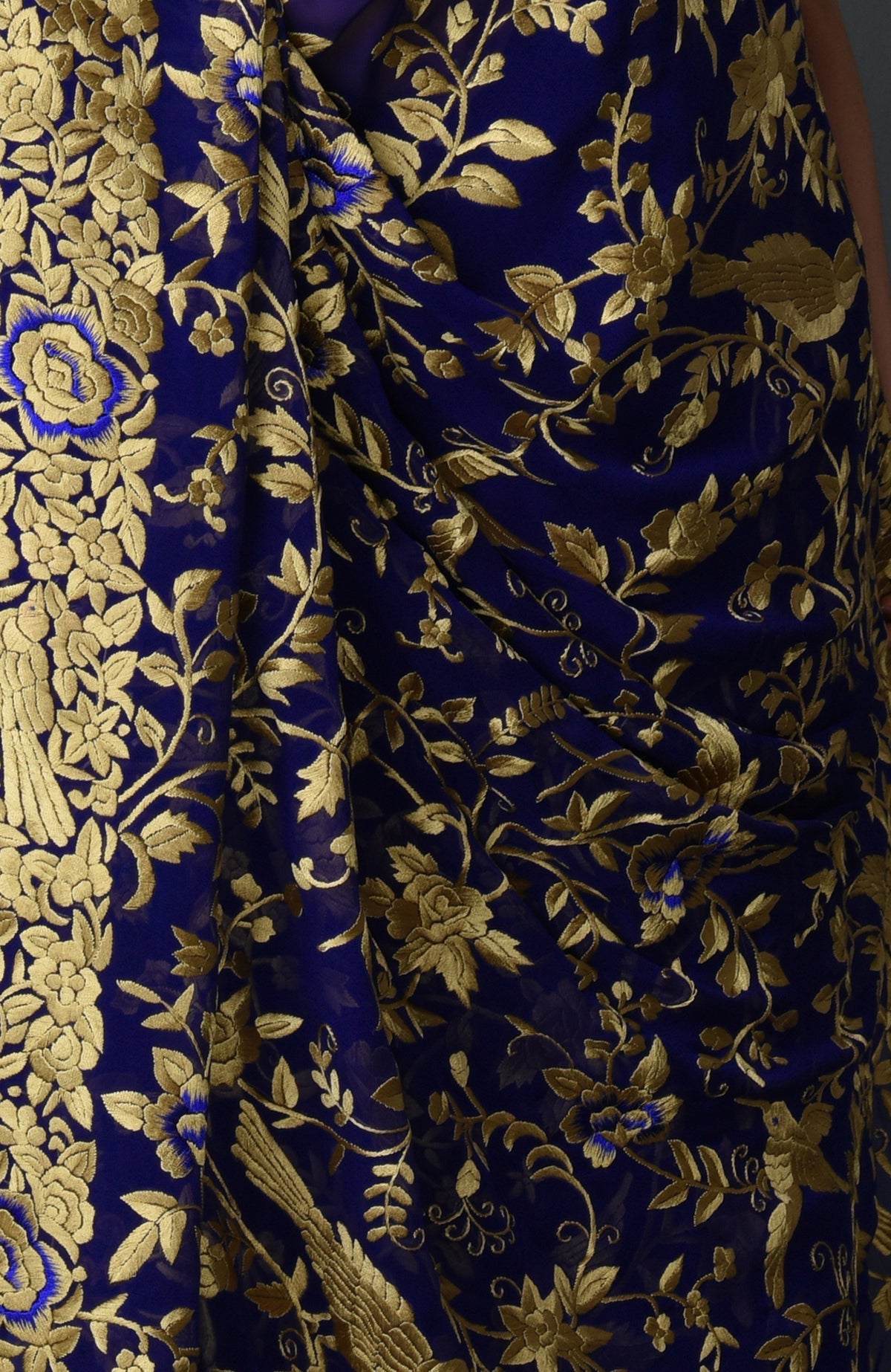 Indigo blue Parsi Gara hand-embroidered saree with gold floral and bird patterns.