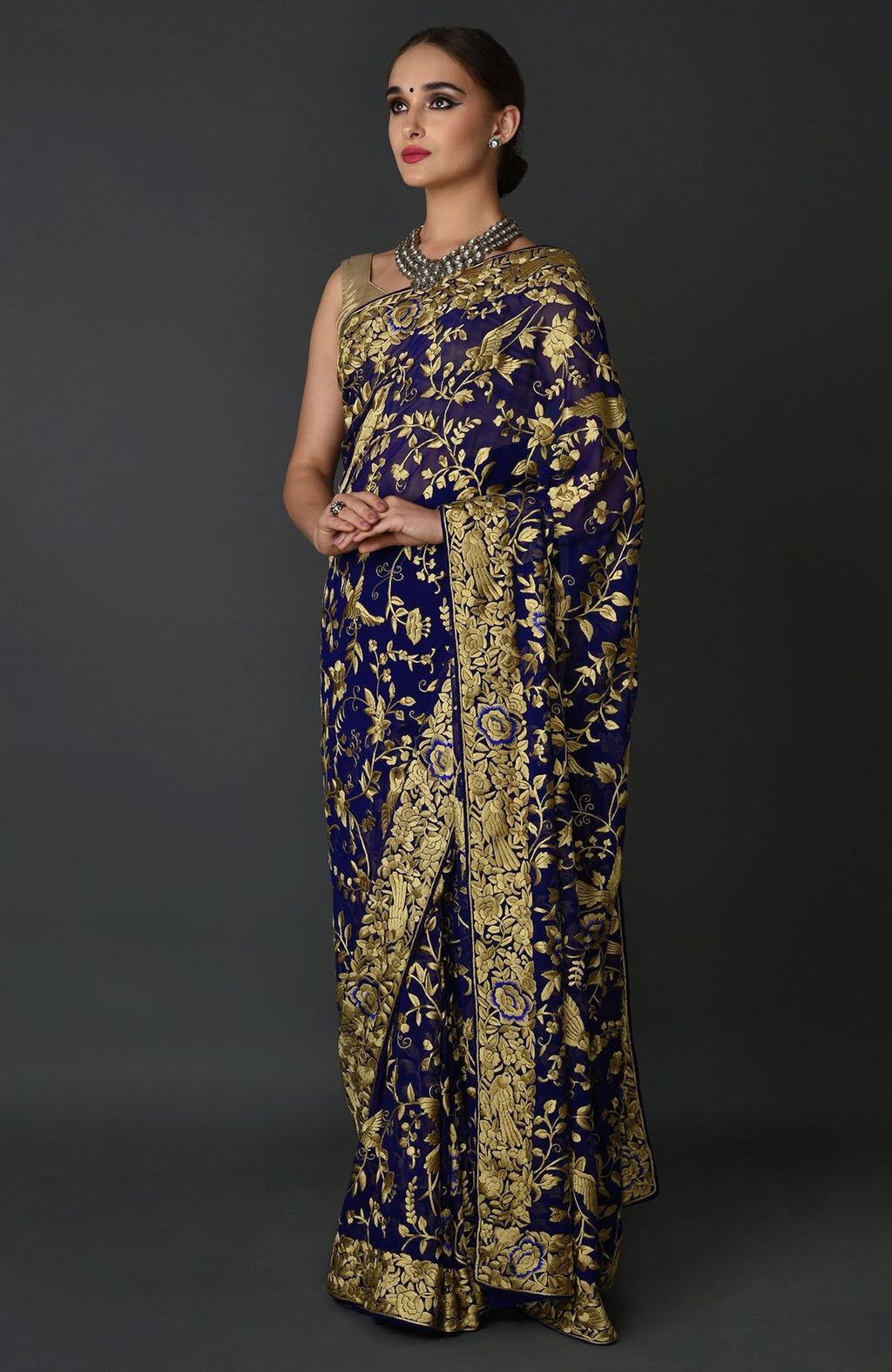 Indigo blue Parsi Gara hand embroidered saree with gold floral and bird motifs.